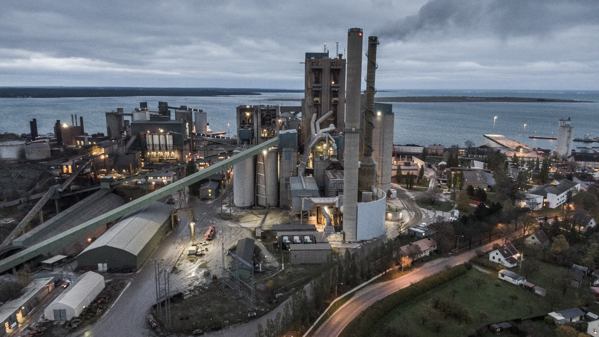 Cement factory with large smokestacks emitting thick white and gray industrial smoke